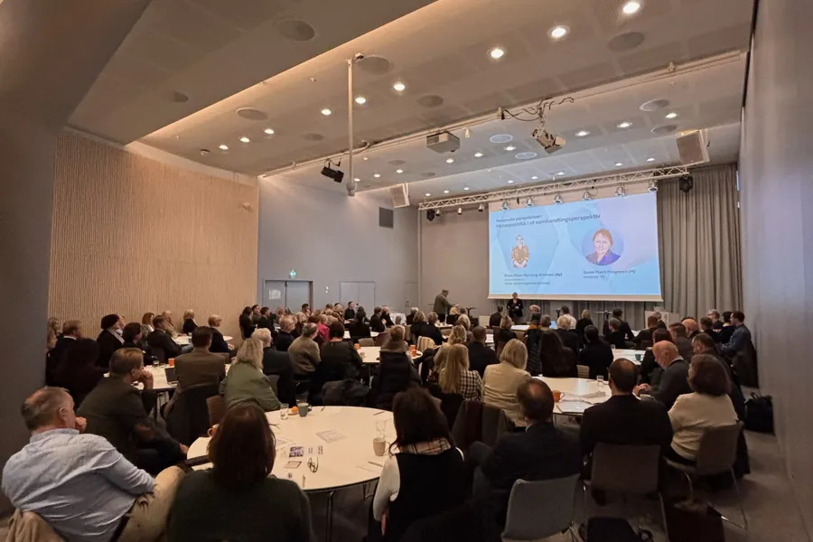 En gruppe mennesker som sitter i et rom og ser på en skjerm